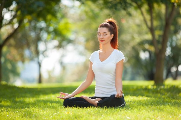 Mujer meditando en el parque